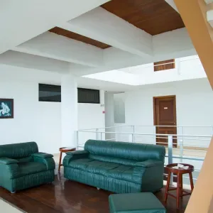 Representative hotel space: A lounge with green upholstered seating and a wooden floor.