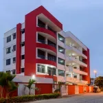 Representative hotel space: A modern multistory building with red exterior accents and balconies.