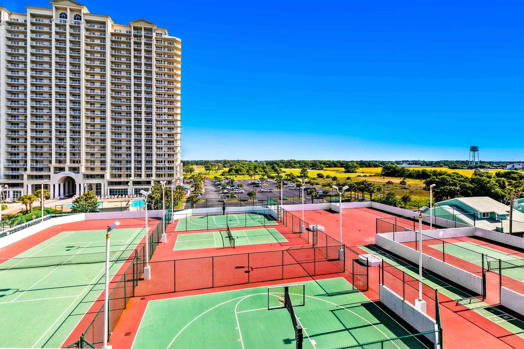 Shared amenity: Outdoor sports courts with green playing surfaces and red surrounding areas.