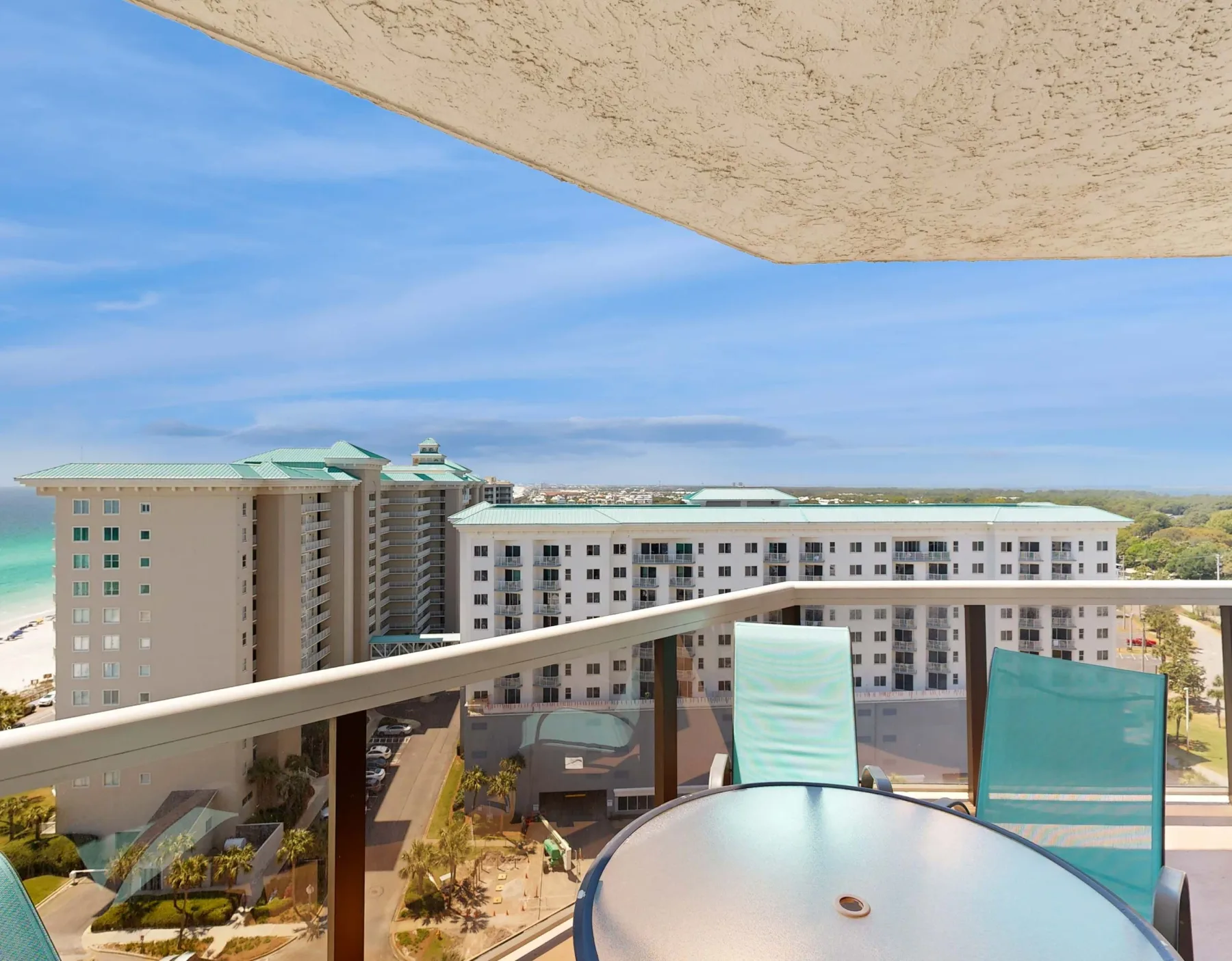 A balcony seating area overlooks nearby buildings and landscaped grounds.