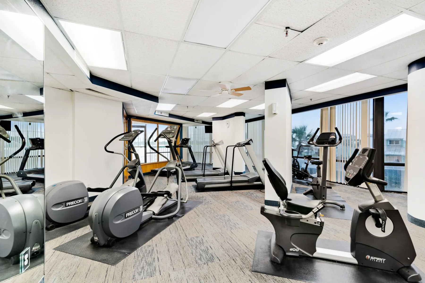 Shared amenity: A fitness room with exercise machines and large windows.