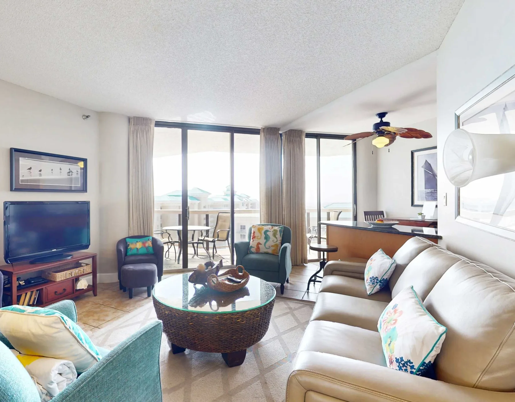 A bright living room with seating around a coffee table and large windows.