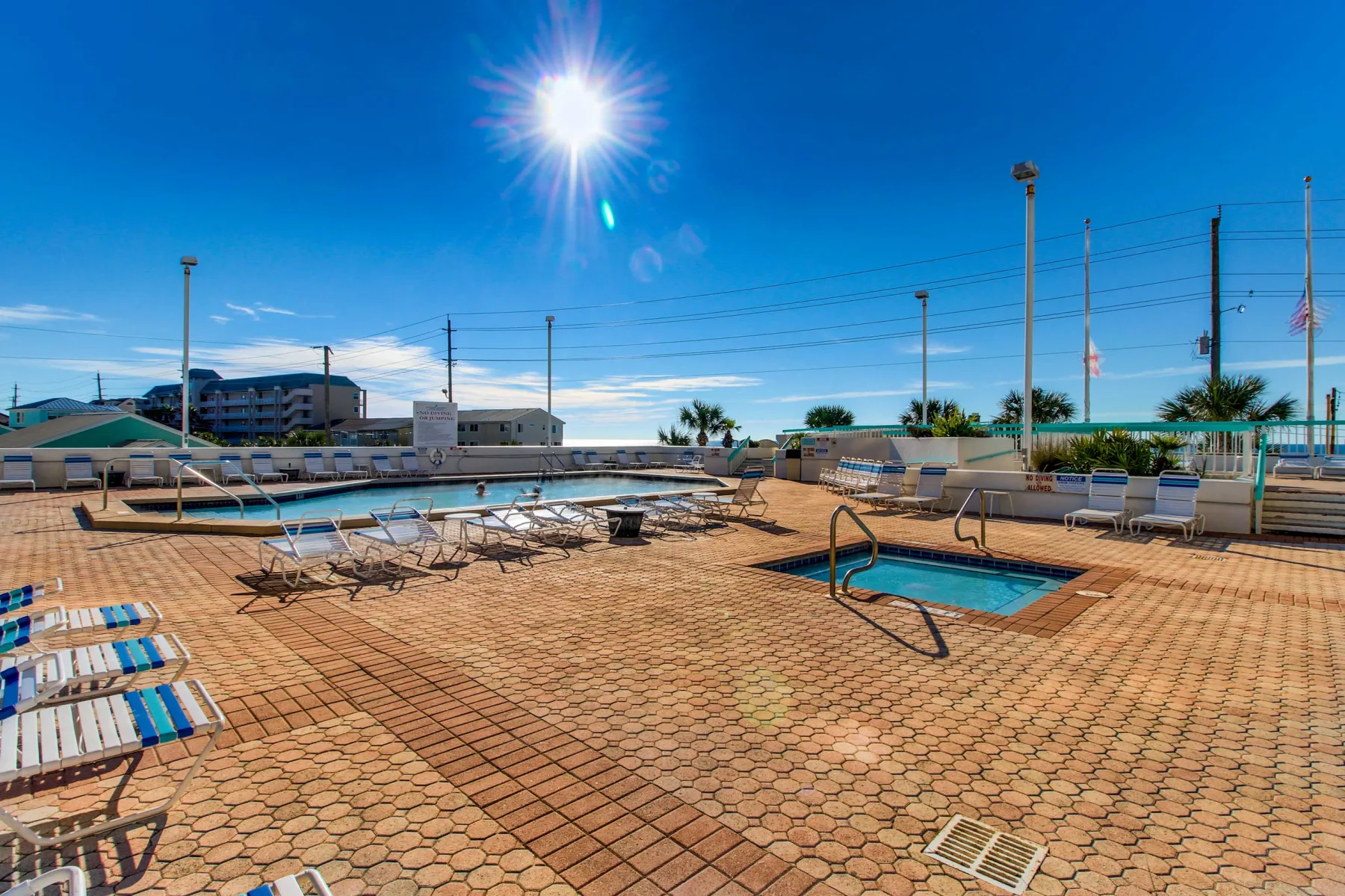 Shared amenity: A sunlit outdoor pool deck with lounge seating and a small swimming pool.