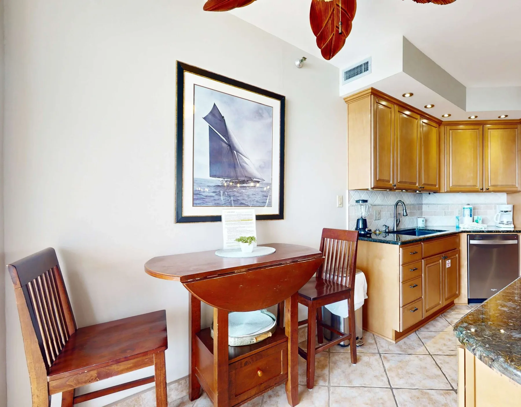 A dining area with a wooden table and chairs beside a kitchen.