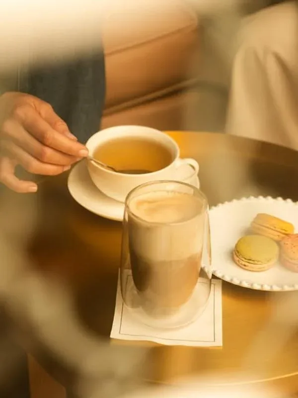 Representative hotel space: A café table with tea, a layered coffee drink, and pastries.