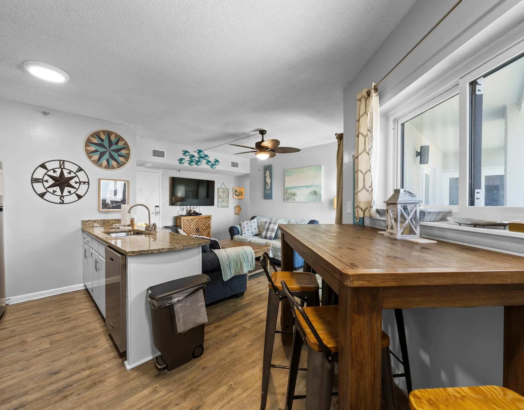 An open-plan kitchen and living area with a wooden island and dining table.