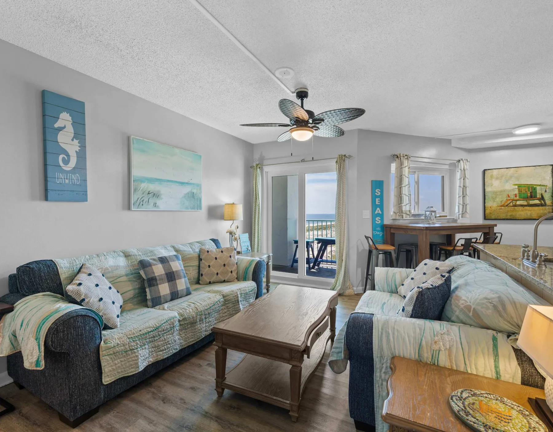 Living room with seating, a coffee table, and a ceiling fan.