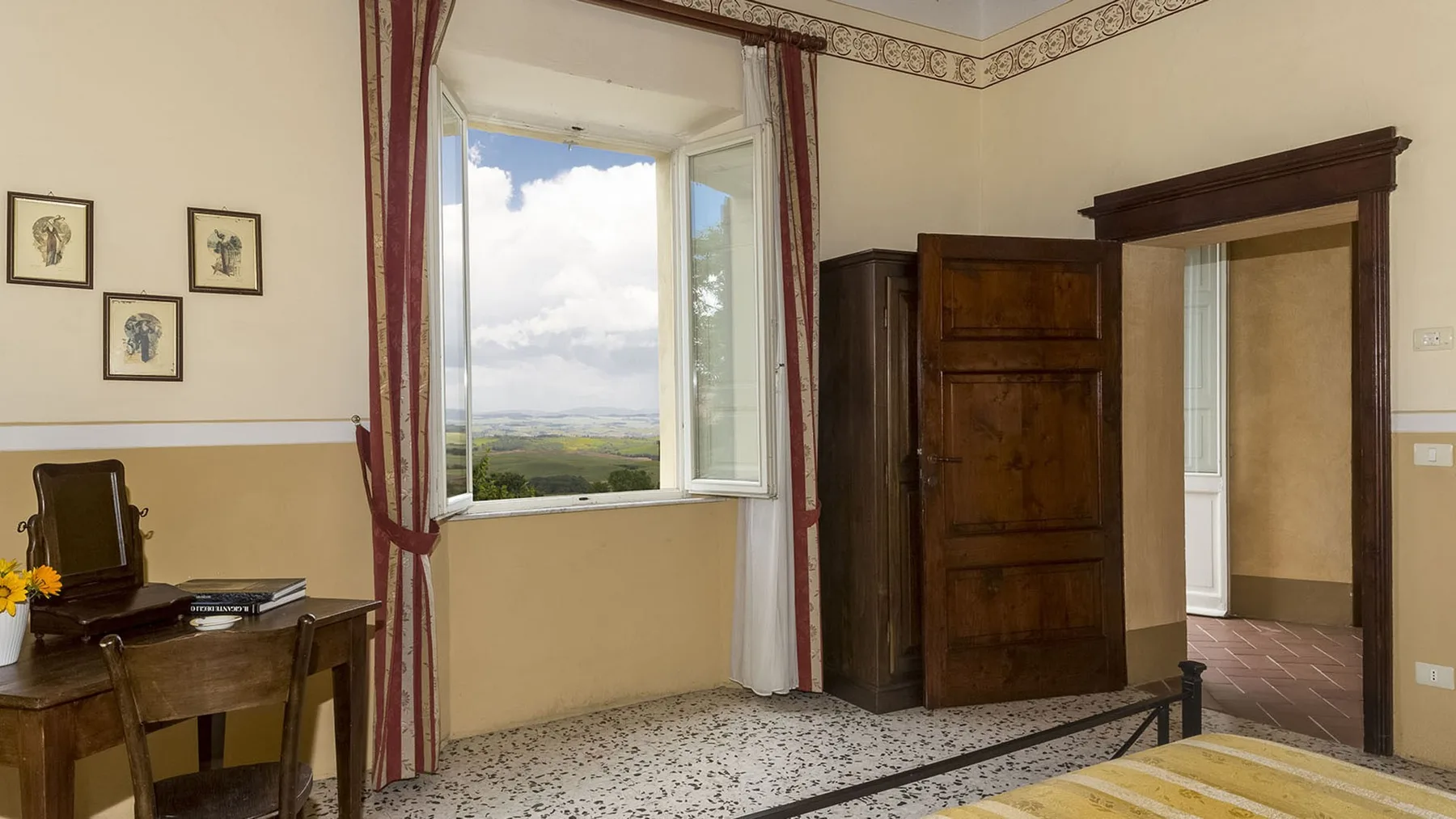 Un dormitorio con una cama de madera, una ventana abierta y un escritorio.