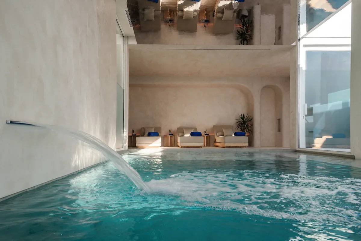 Espacio representativo del hotel: Una piscina interior con asientos de descanso junto a la pared del fondo.