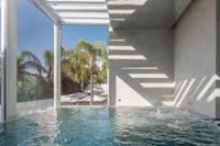 Espacio representativo del hotel: Una piscina interior junto a ventanales y una escalera.