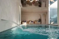 Espacio representativo del hotel: Una piscina cubierta con paredes revestidas y elementos de agua.