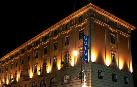 Espacio representativo del hotel: Un edificio de hotel iluminado por la noche con un letrero vertical.