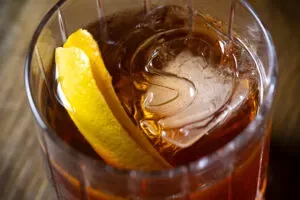 Representative hotel space: A close-up of a dark drink with ice and a lemon wedge.