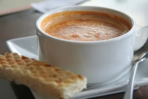 Representative hotel space: A cup of coffee sits beside a piece of pastry on a plate.
