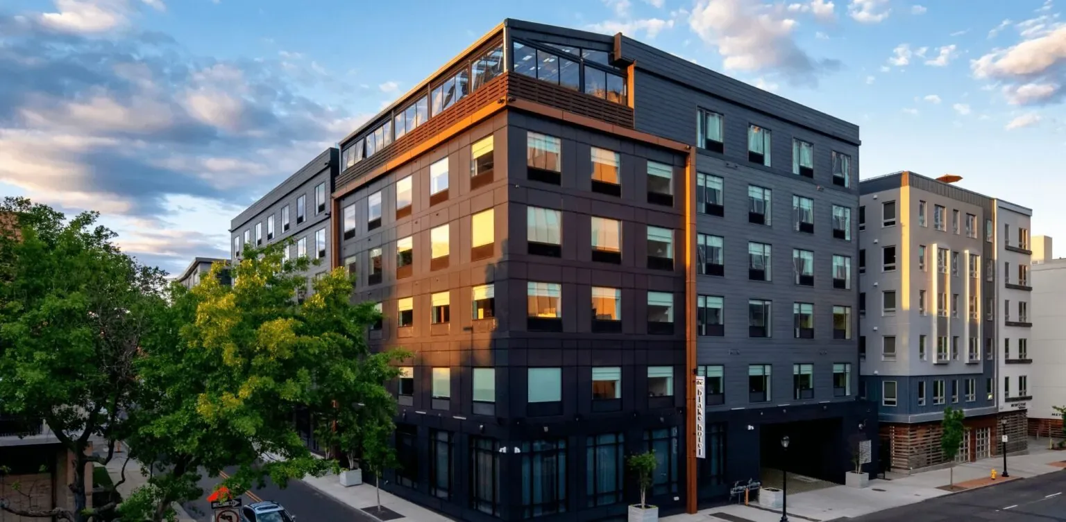 Representative hotel space: A multi-story modern building stands along a tree-lined street.
