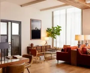 Representative hotel space: A bright living room with seating, a coffee table, and large windows.