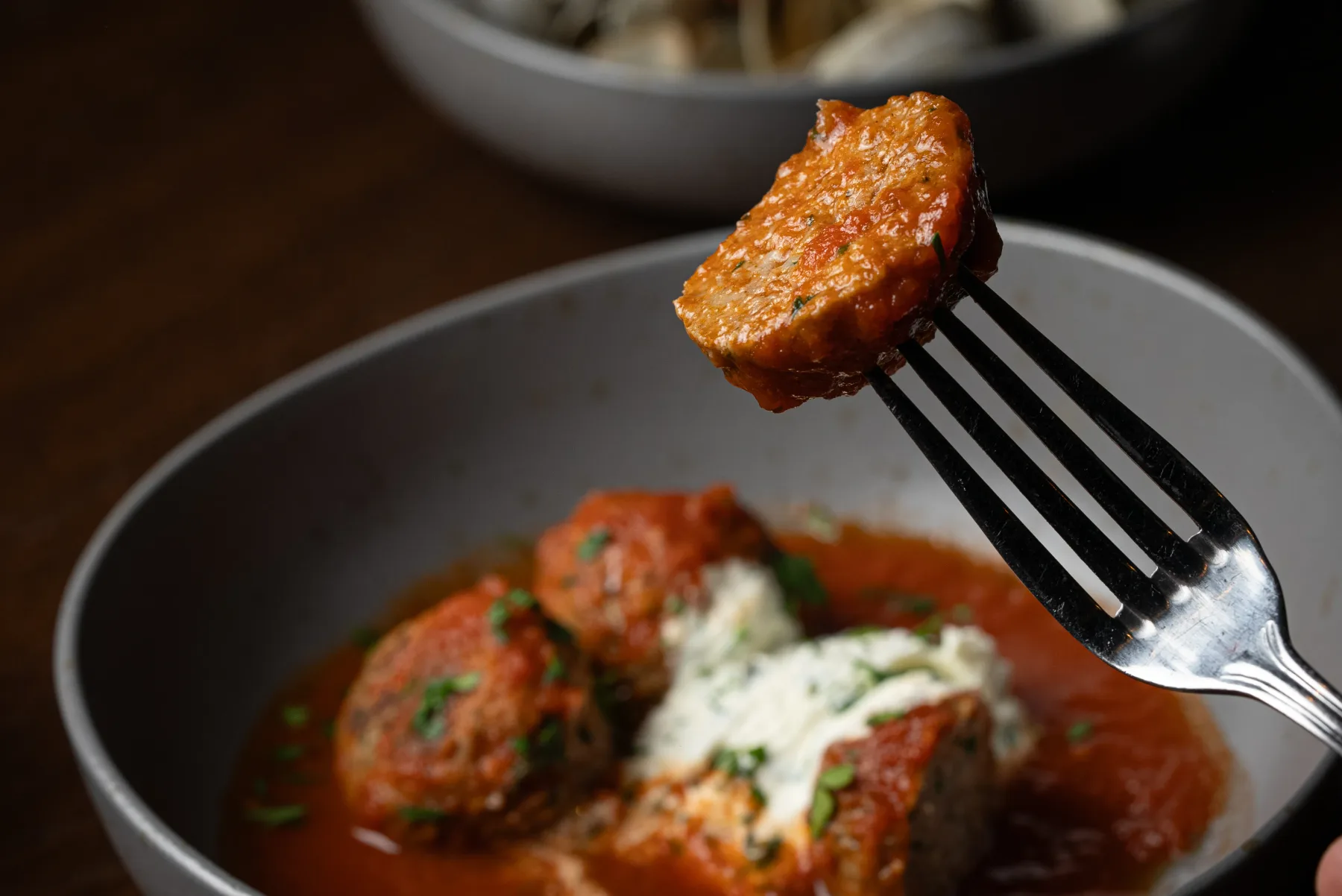 Representative hotel space: A close-up of meatballs in tomato sauce, with one held on a fork.