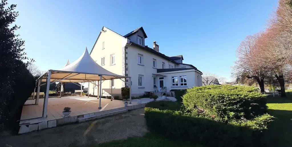 Representative hotel space: A white building with a covered patio stands beside landscaped greenery.