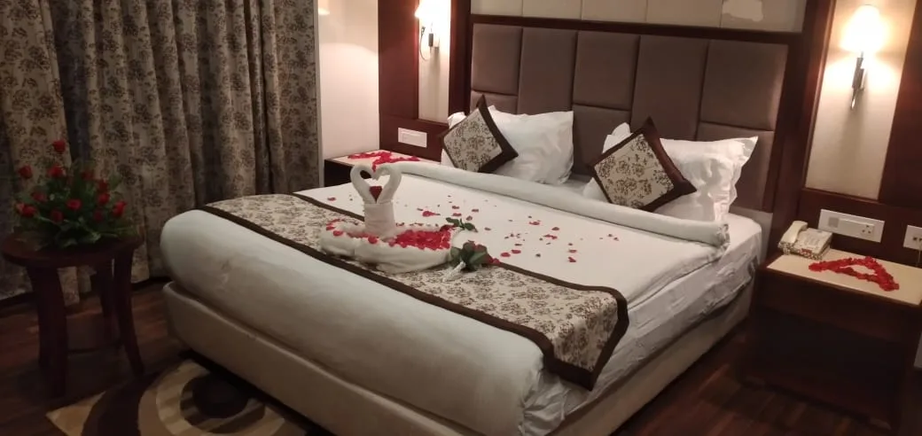 Espacio representativo del hotel: Un dormitorio con una cama grande vestida con ropa de cama blanca y cojines decorativos.