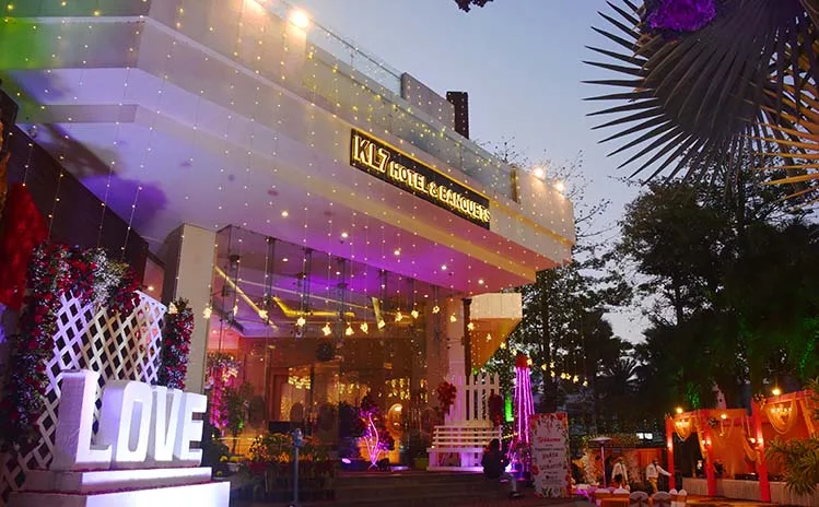 Espacio representativo del hotel: La entrada de un hotel brilla con luces de colores junto a un gran letrero LOVE.