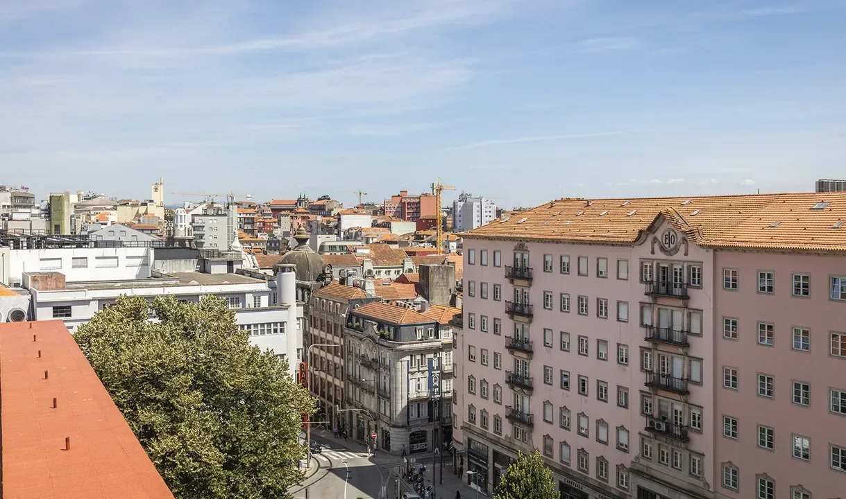 Representative hotel space: A cityscape of closely spaced buildings beneath a partly cloudy sky.