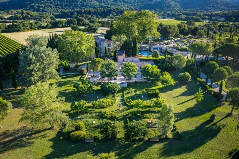 Representative hotel space: A landscaped property with gardens, trees, and a swimming pool.
