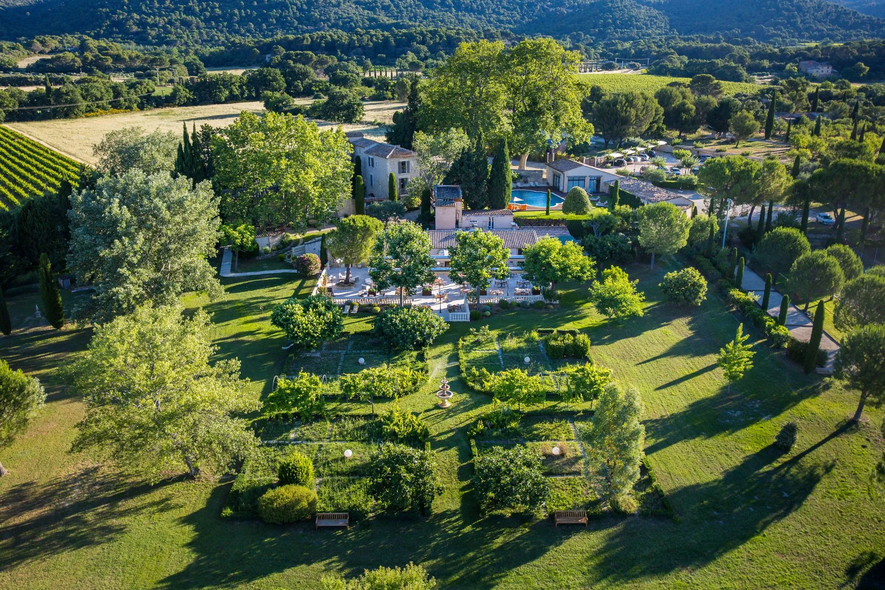 Representative hotel space: A landscaped garden surrounds a swimming pool and outdoor seating.