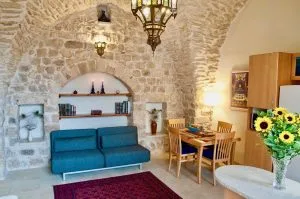 Representative hotel space: A stone-walled sitting area with blue seating and a dining table.