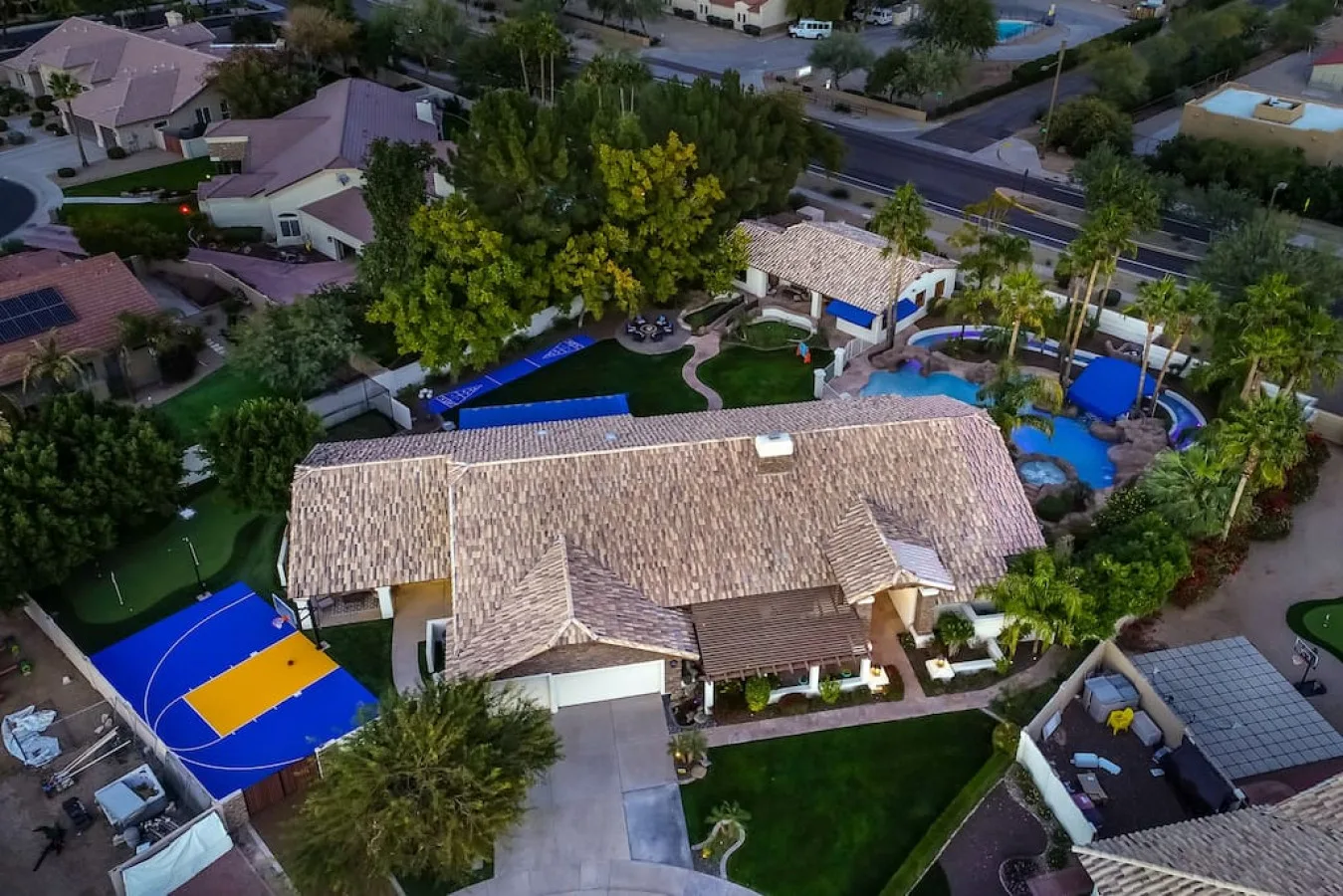 Vista aérea de una casa grande con jardín ajardinado y piscina.