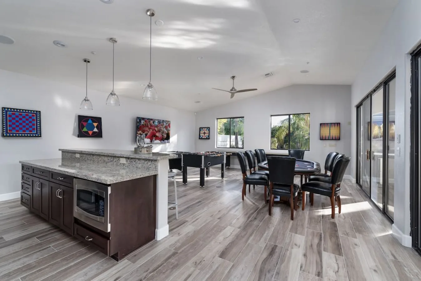 Un luminoso espacio abierto de comedor y cocina con una isla central y una mesa de comedor.