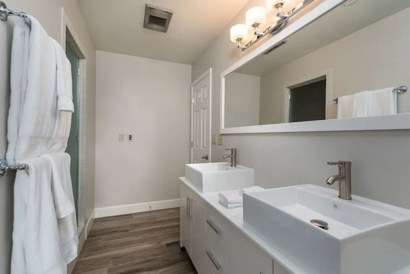 Un tocador de baño con dos lavabos y un espejo grande.