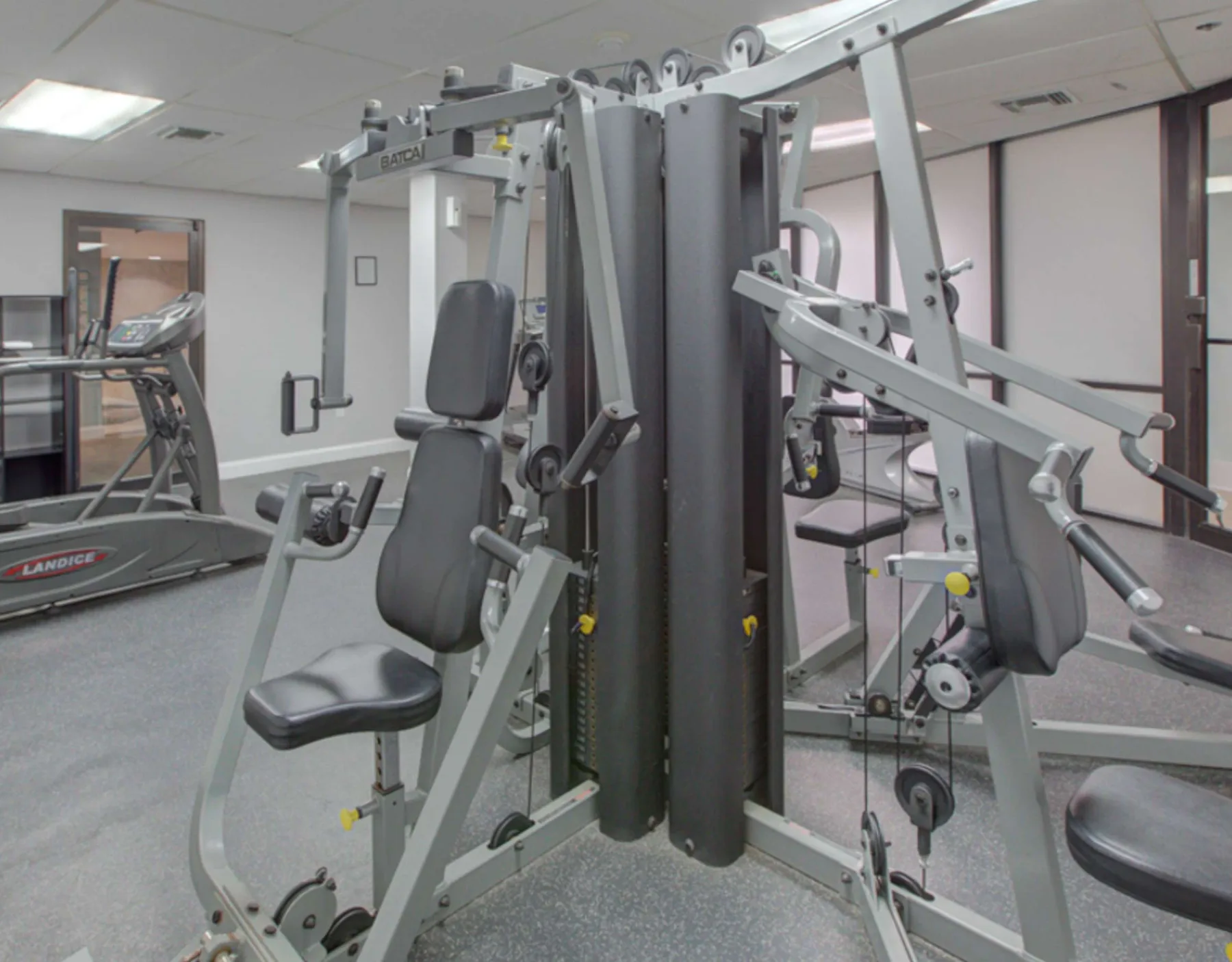 Zona común: Gimnasio con máquinas de pesas y una cinta de correr.