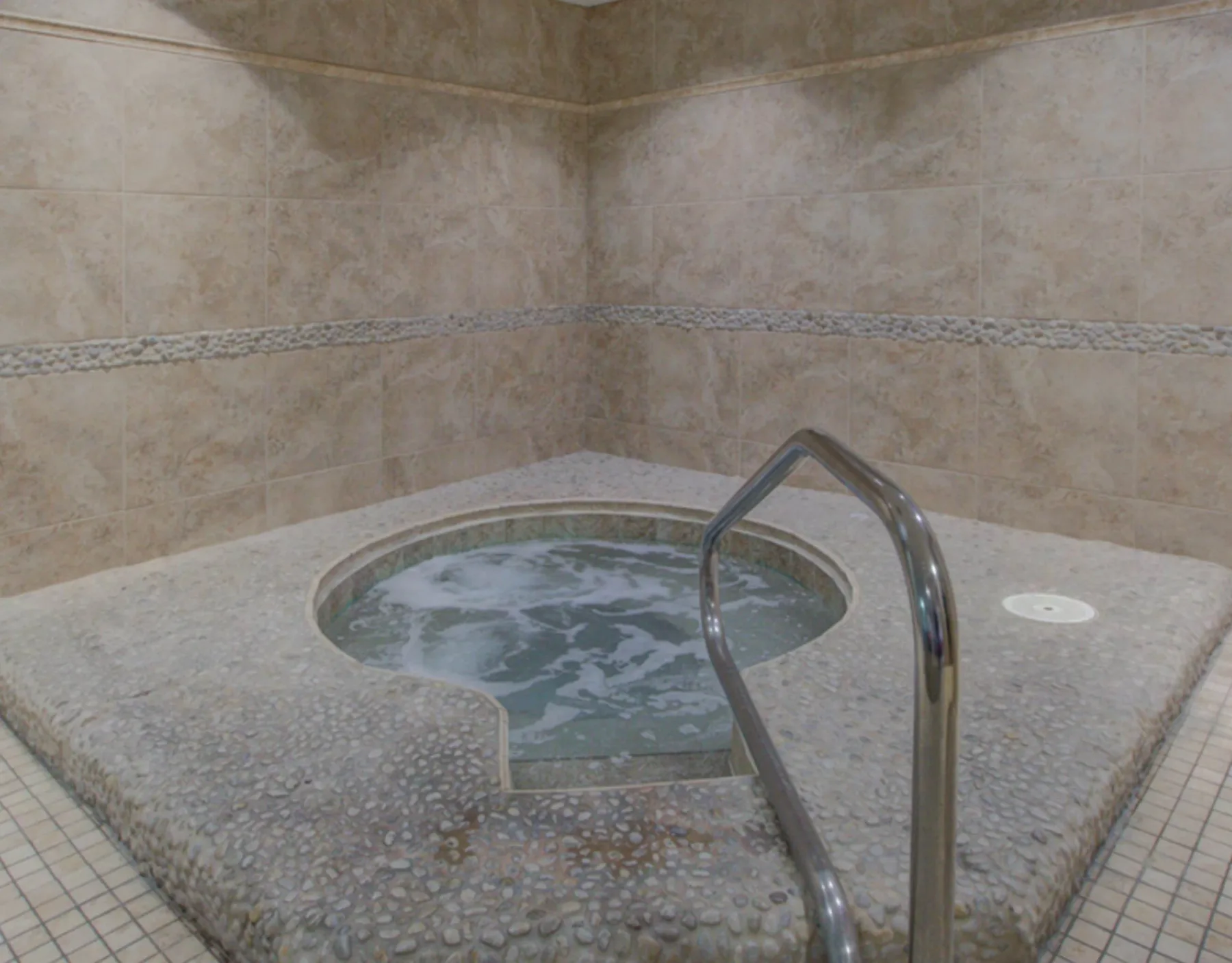 Zona común: Un pequeño jacuzzi interior se encuentra en una zona con paredes de azulejos.