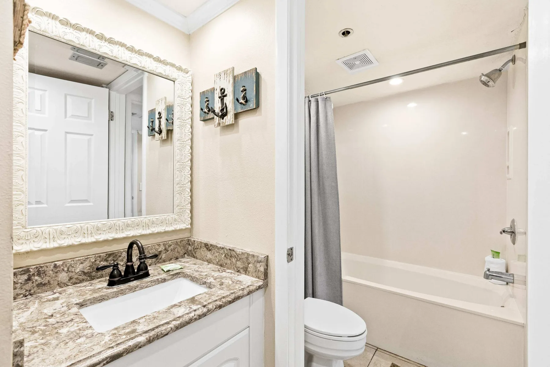 Un baño con lavabo y espejo junto a una bañera con ducha.