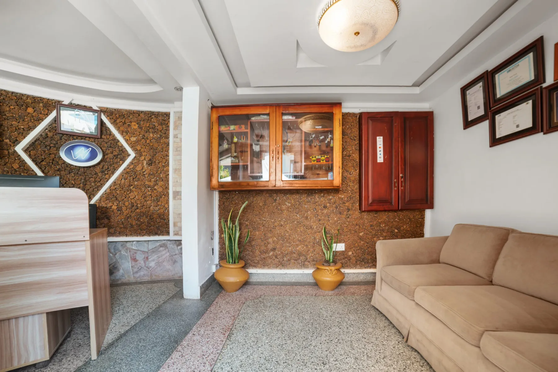 Representative hotel space: A hotel lobby seating area with a reception desk and wall display.