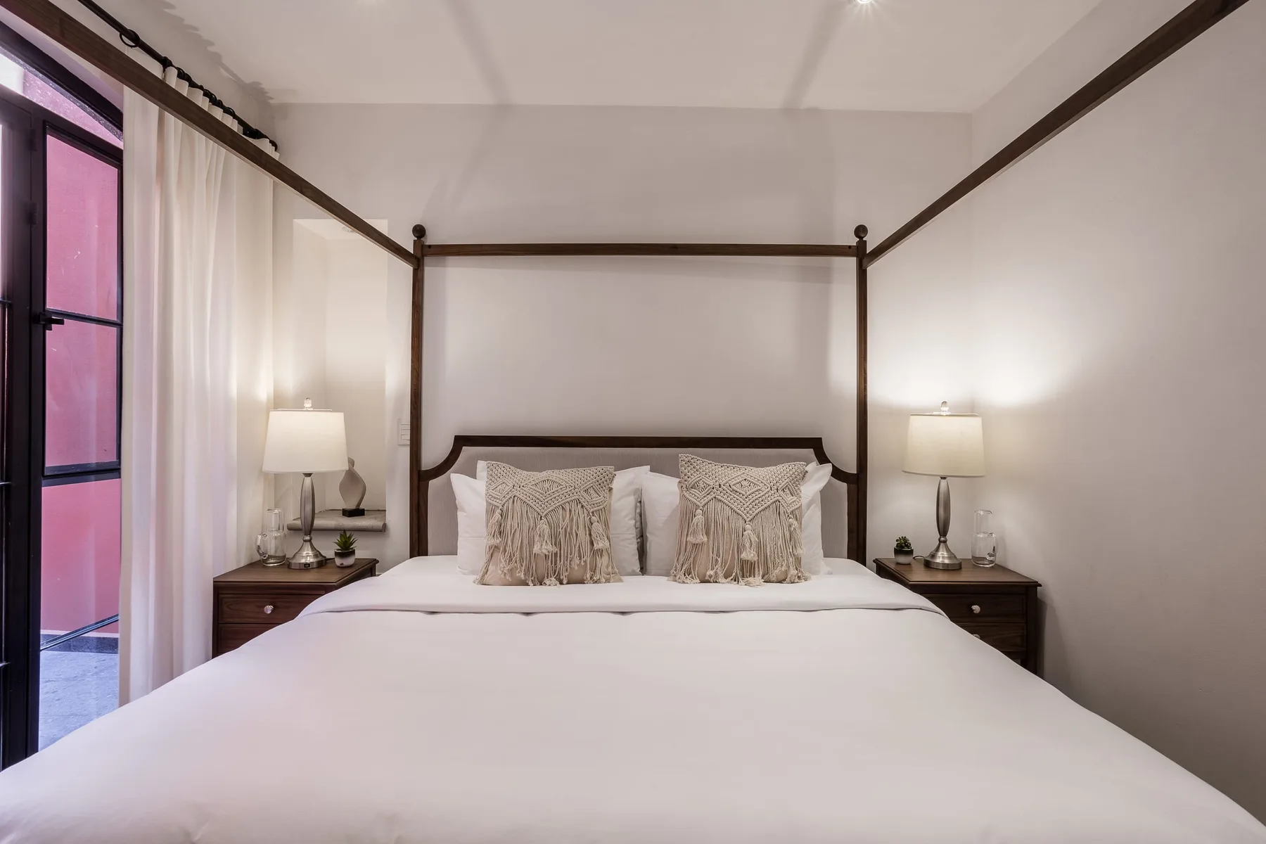 A bedroom with a neatly made bed and matching bedside tables.