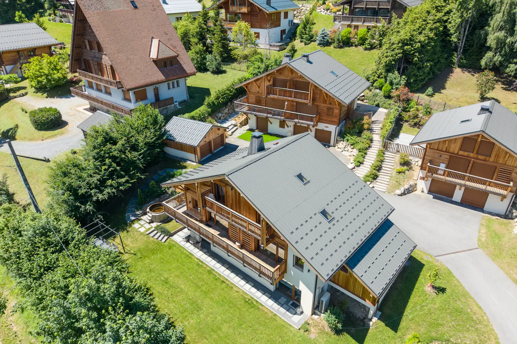 Aerial view of several chalet-style buildings surrounded by greenery.