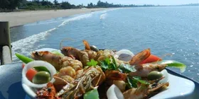 Representative hotel space: A seafood platter sits beside a beach with waves along the shore.