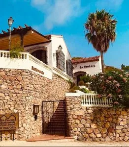 Representative hotel space: A stone entrance courtyard with stairs leading between white buildings.