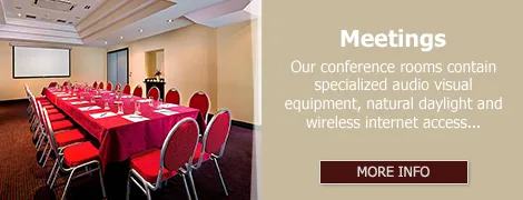Representative hotel space: Conference room arranged with tables and red seating.