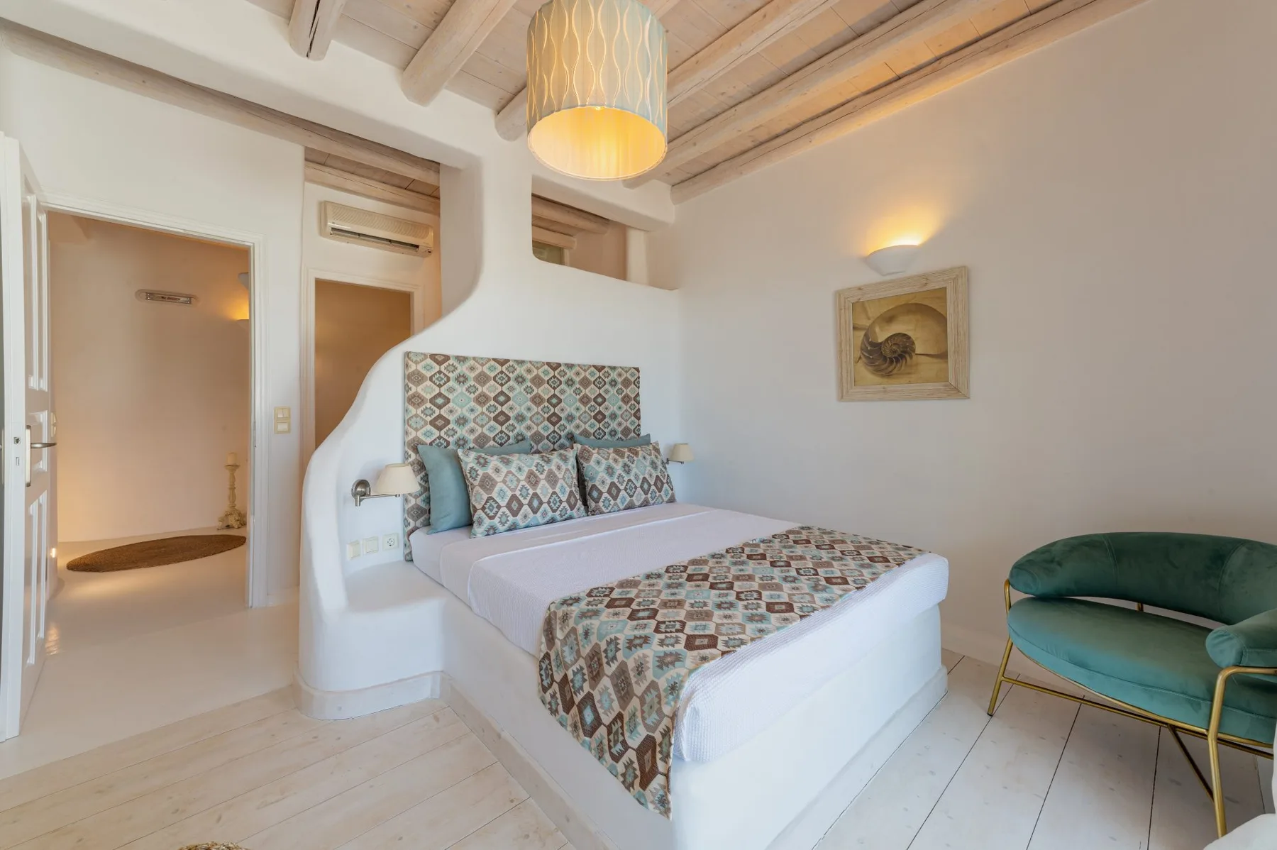 Un dormitorio con una cama estampada y una silla verde al lado.