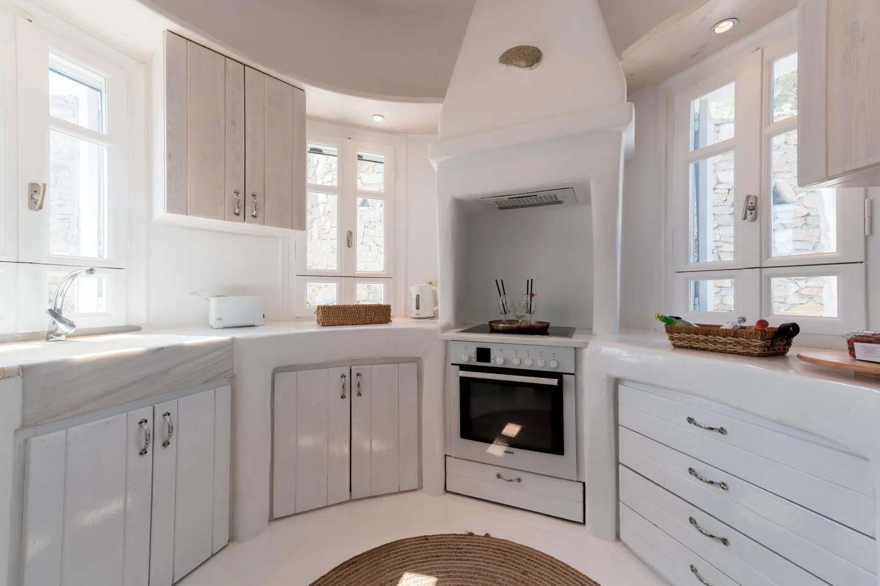 Una cocina luminosa con gabinetes claros, una encimera y un horno empotrado.