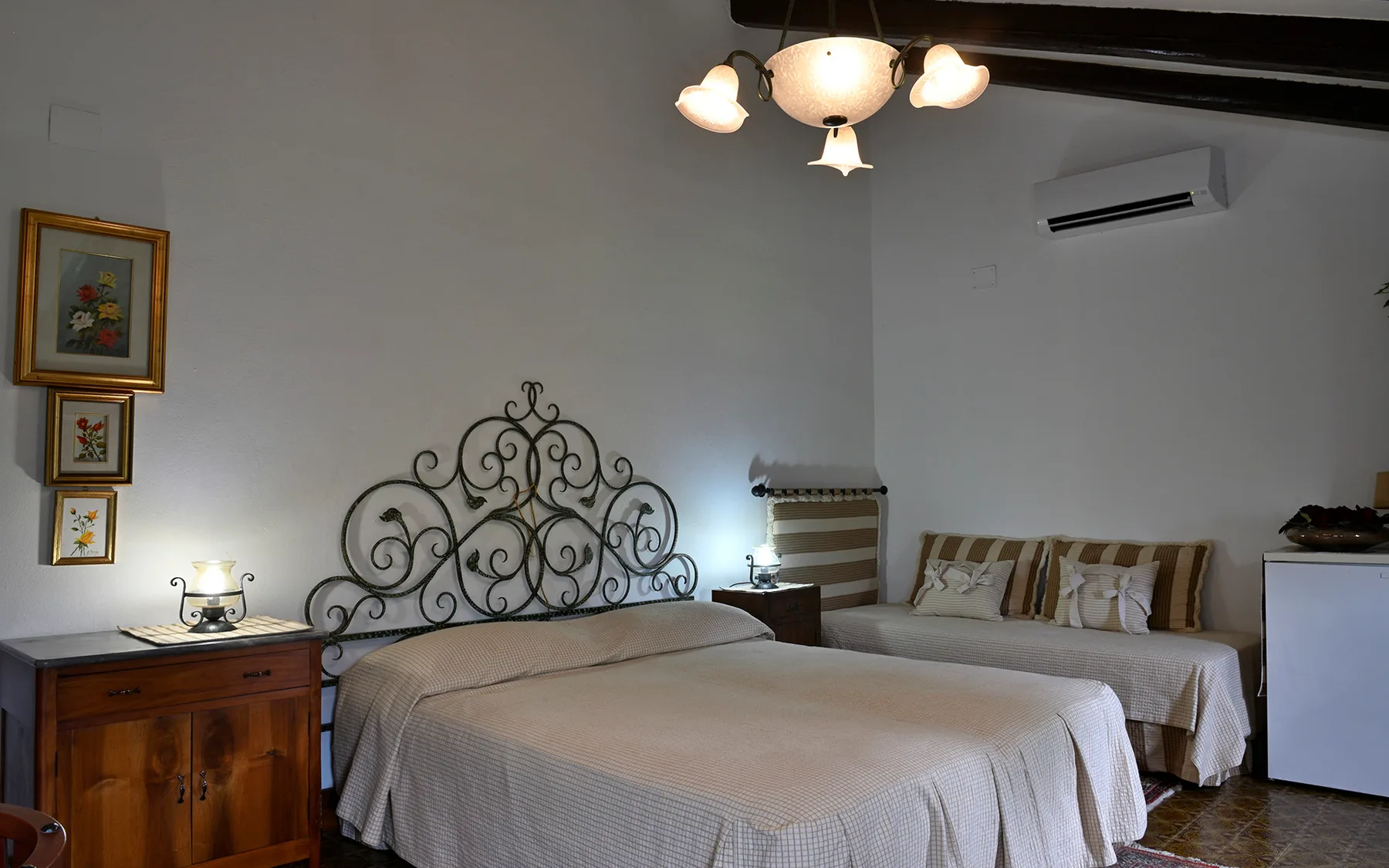 Representative hotel space: A bedroom with two beds and a wooden bedside cabinet.