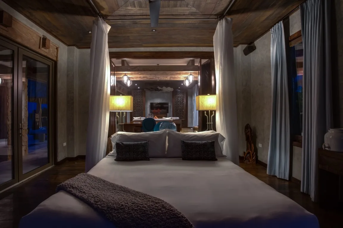 A bedroom with a large bed and curtains around the sleeping area.