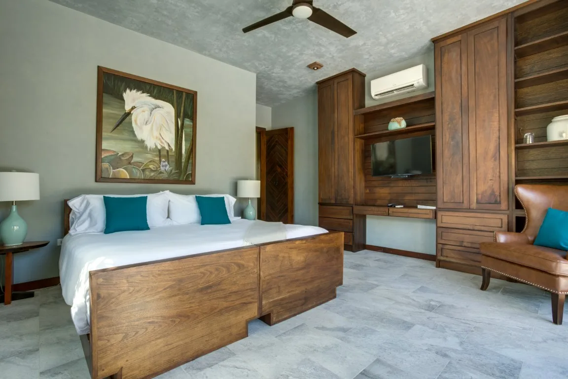 A bedroom with a bed and built-in wooden cabinetry along the wall.