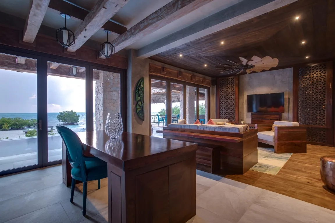 A spacious living room with a dining table, seating, and a view of the water.