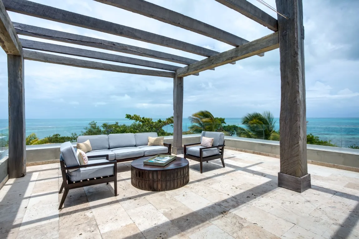 A rooftop terrace with outdoor seating and a view of the ocean.