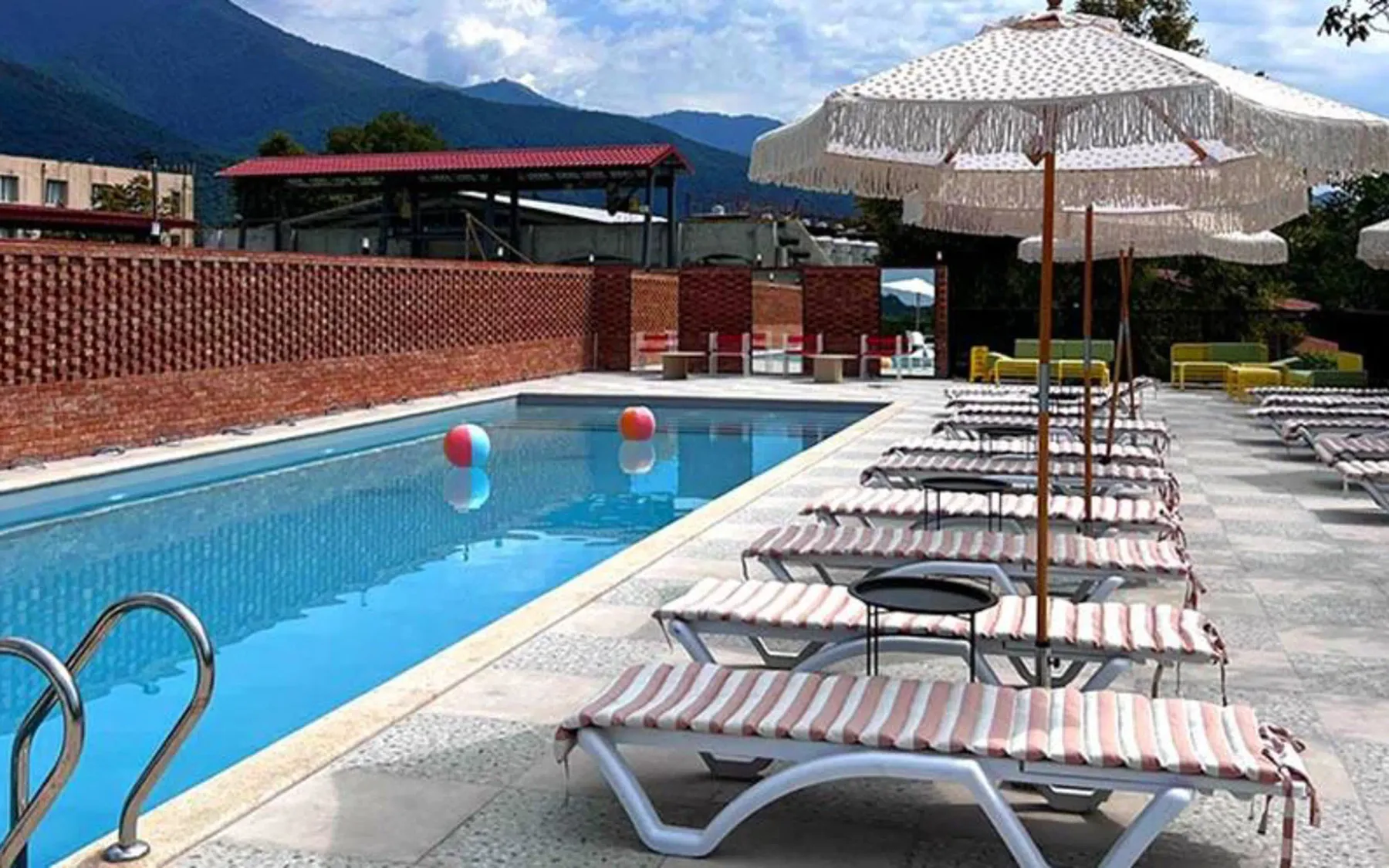 Representative hotel space: An outdoor swimming pool is lined with lounge chairs and parasols.