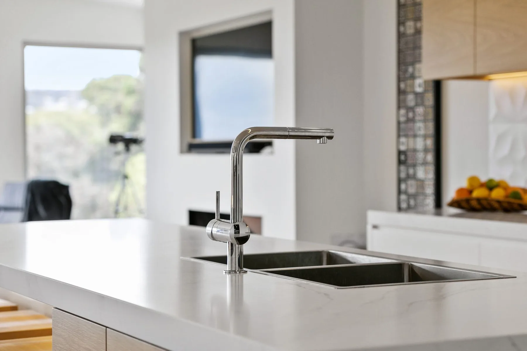 Una cocina luminosa con fregadero y ventanas grandes.