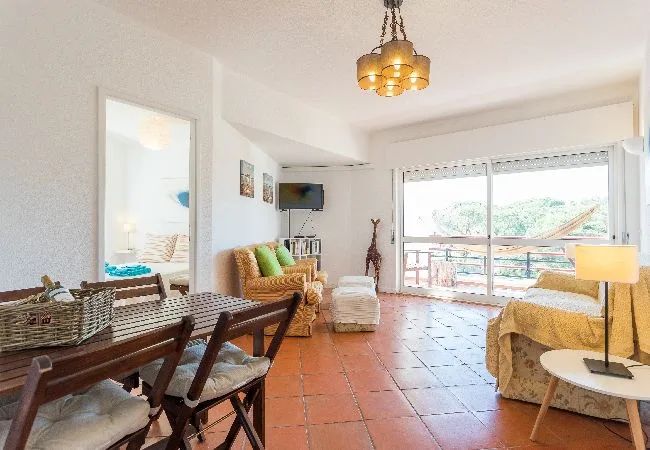 Una sala luminosa con asientos y grandes puertas de vidrio que dan a un balcón.